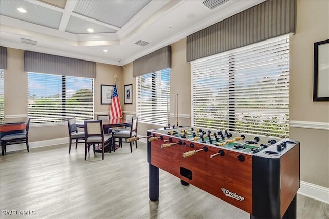 game room with a tray ceiling, crown molding, coffered ceiling, and light wood-type flooring