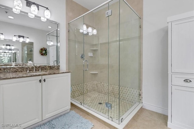 bathroom with tile patterned flooring, vanity, and walk in shower