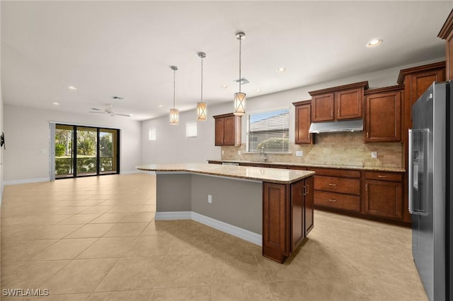 kitchen featuring stainless steel fridge with ice dispenser, a kitchen island, open floor plan, under cabinet range hood, and backsplash