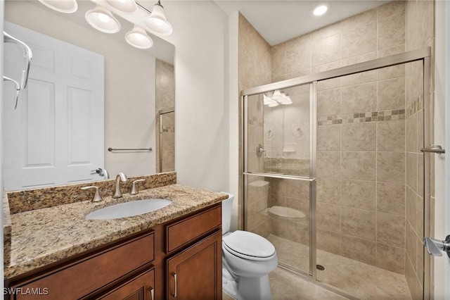 bathroom featuring a shower stall, toilet, and vanity