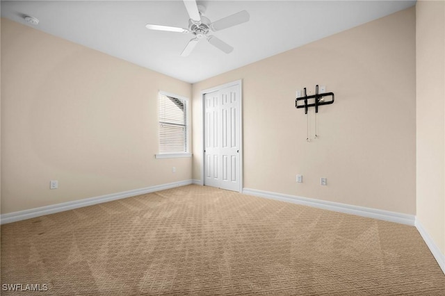 spare room with a ceiling fan, carpet, and baseboards