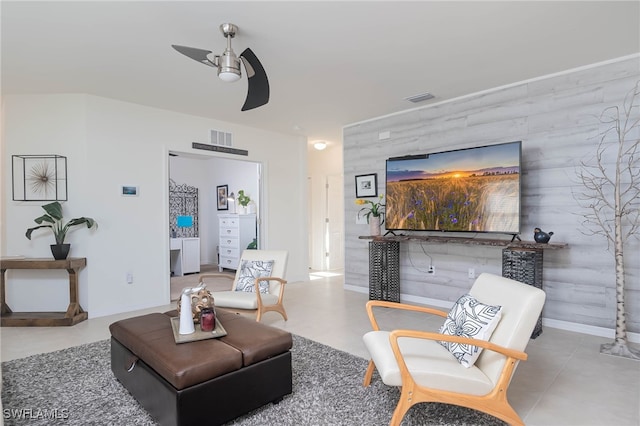 living room featuring ceiling fan and wooden walls