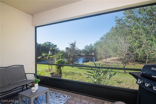 sunroom / solarium featuring a water view