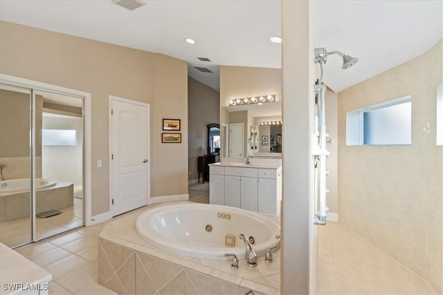 bathroom with tile patterned floors, tiled bath, vanity, and vaulted ceiling