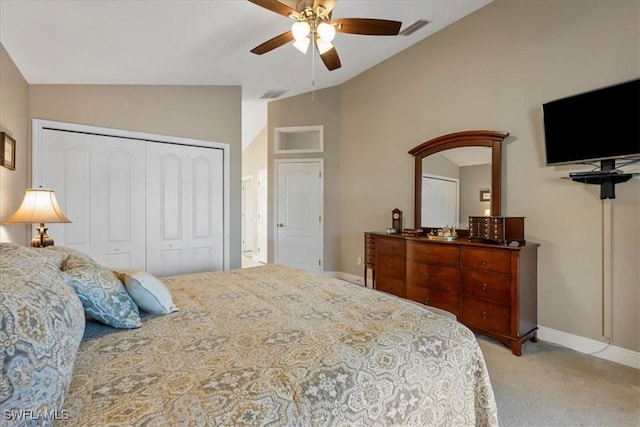 carpeted bedroom with a closet, lofted ceiling, and ceiling fan