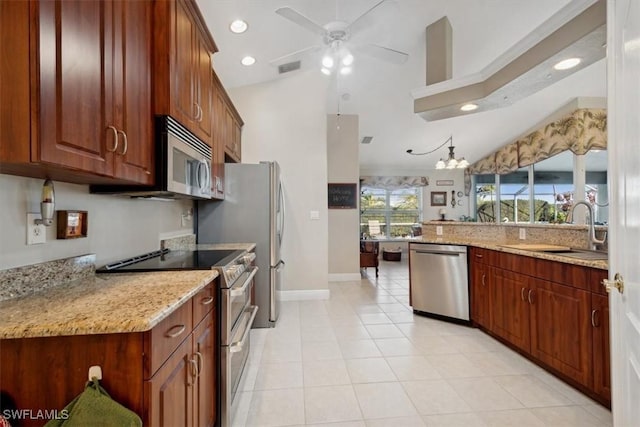 kitchen with sink, light stone counters, light tile patterned flooring, ceiling fan with notable chandelier, and appliances with stainless steel finishes