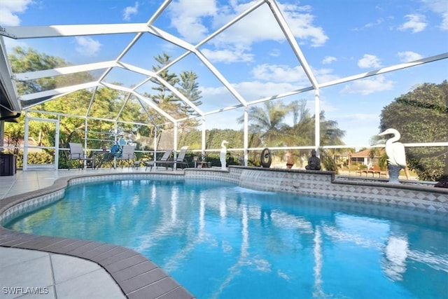 view of pool featuring glass enclosure and a patio