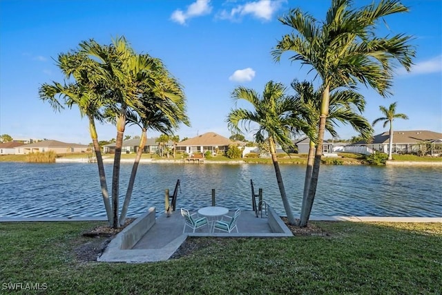 view of dock with a lawn and a water view