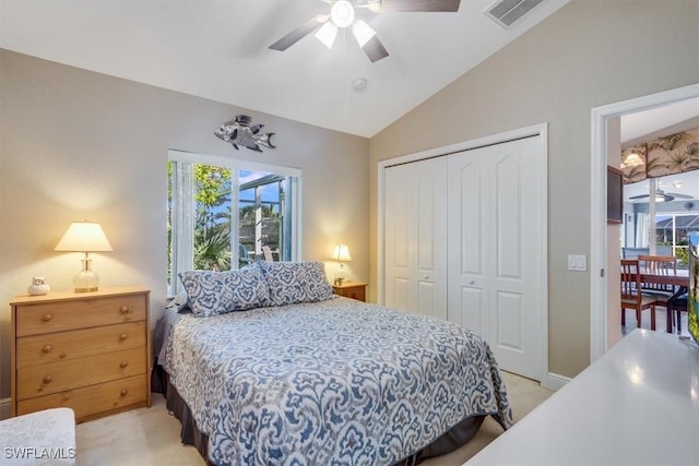 carpeted bedroom with ceiling fan, vaulted ceiling, and a closet