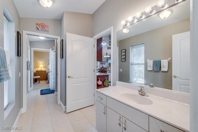 bathroom featuring tile patterned floors, vanity, and lofted ceiling