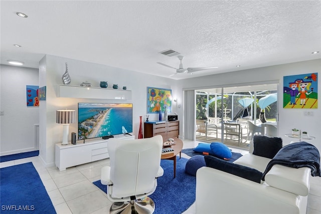 tiled living room with ceiling fan and a textured ceiling