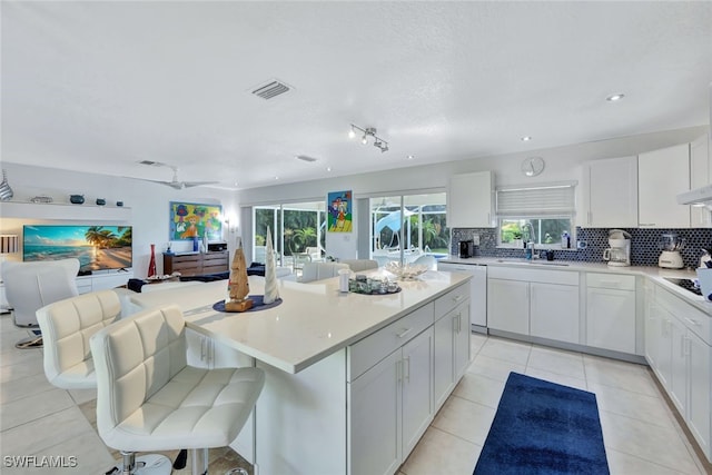 kitchen with a center island, white cabinets, white dishwasher, and sink