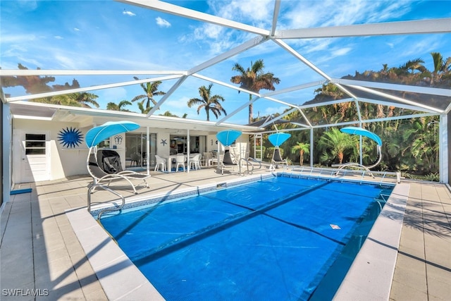 view of swimming pool with glass enclosure and a patio area