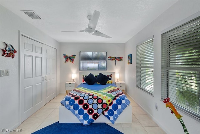 bedroom featuring light tile patterned flooring, a closet, and ceiling fan