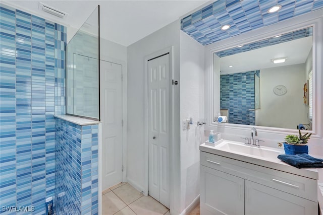 bathroom featuring tile patterned floors, vanity, and tiled shower