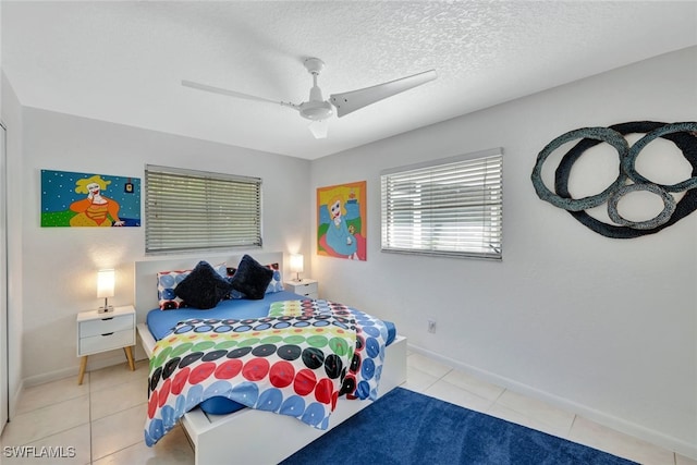 tiled bedroom with a textured ceiling and ceiling fan