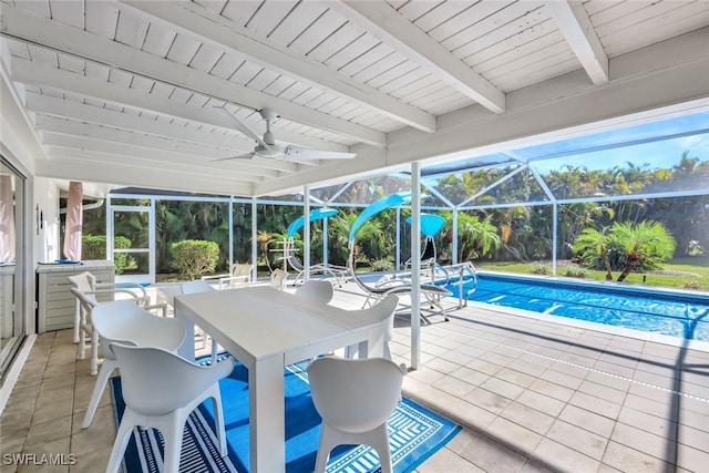 view of swimming pool with a patio area, ceiling fan, and glass enclosure