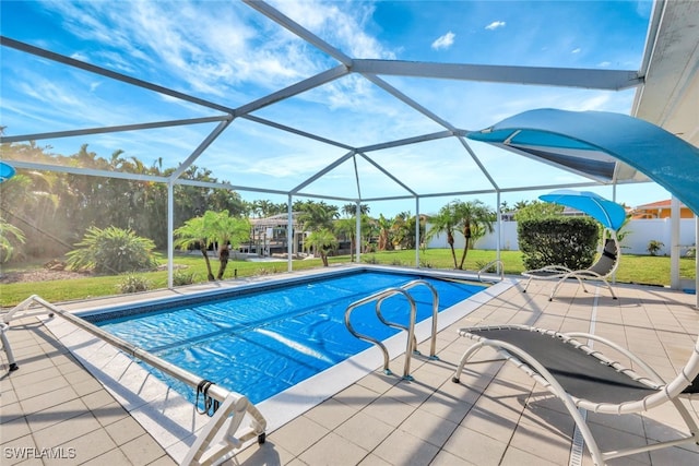 view of pool featuring a lawn, glass enclosure, and a patio area