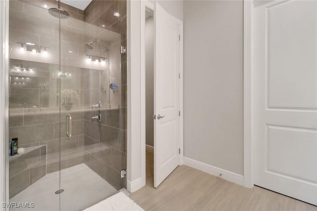 bathroom featuring an enclosed shower and wood-type flooring