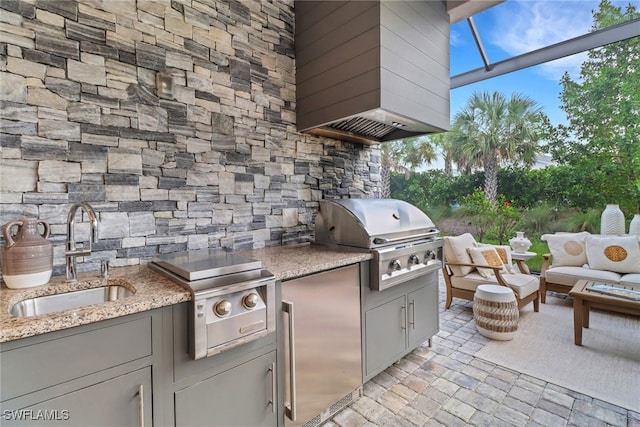 view of patio featuring an outdoor kitchen, a grill, and sink