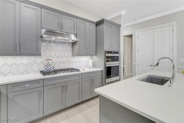 kitchen with gray cabinets, appliances with stainless steel finishes, sink, decorative backsplash, and light tile patterned floors