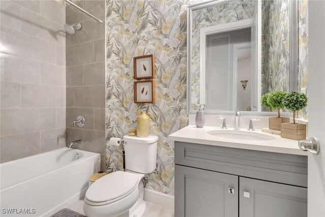 full bathroom featuring tiled shower / bath, vanity, and toilet