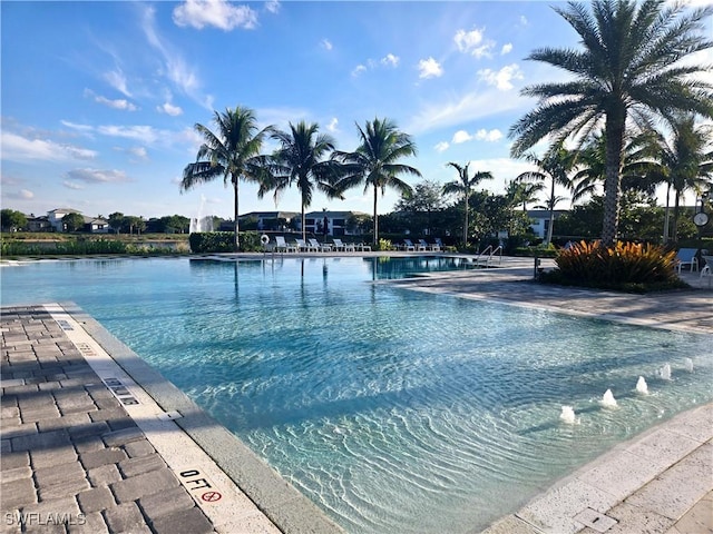 view of pool featuring a water view and a patio area