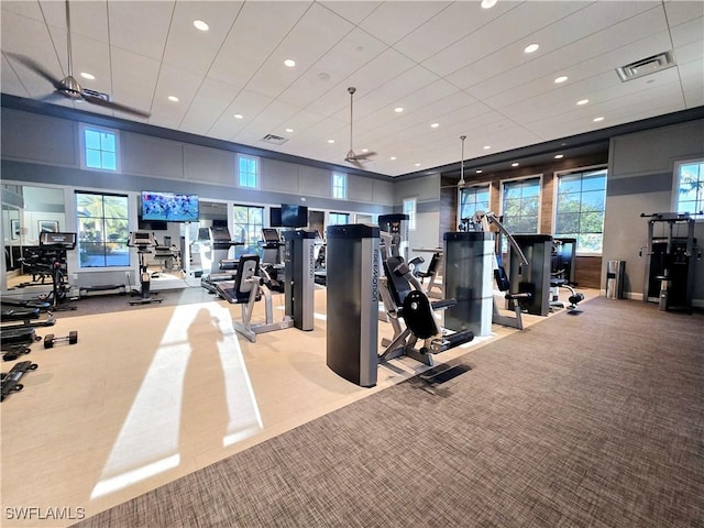 gym featuring ceiling fan and a towering ceiling