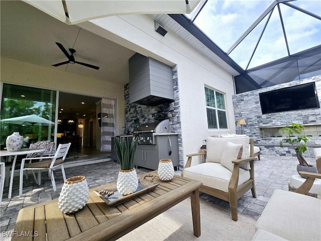 view of patio with outdoor lounge area, area for grilling, a grill, ceiling fan, and glass enclosure