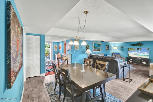 dining space featuring a textured ceiling and hardwood / wood-style flooring