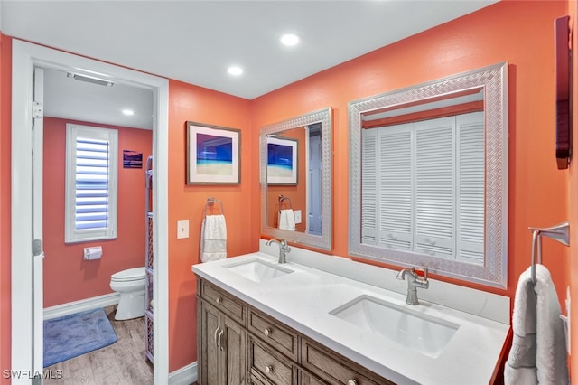 bathroom featuring wood-type flooring, vanity, and toilet