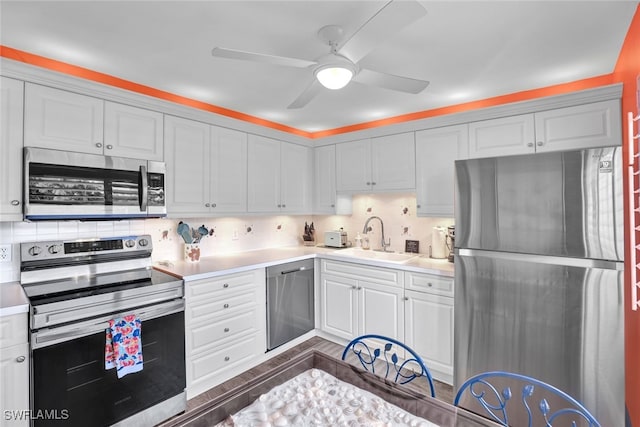 kitchen featuring decorative backsplash, stainless steel appliances, white cabinetry, and sink