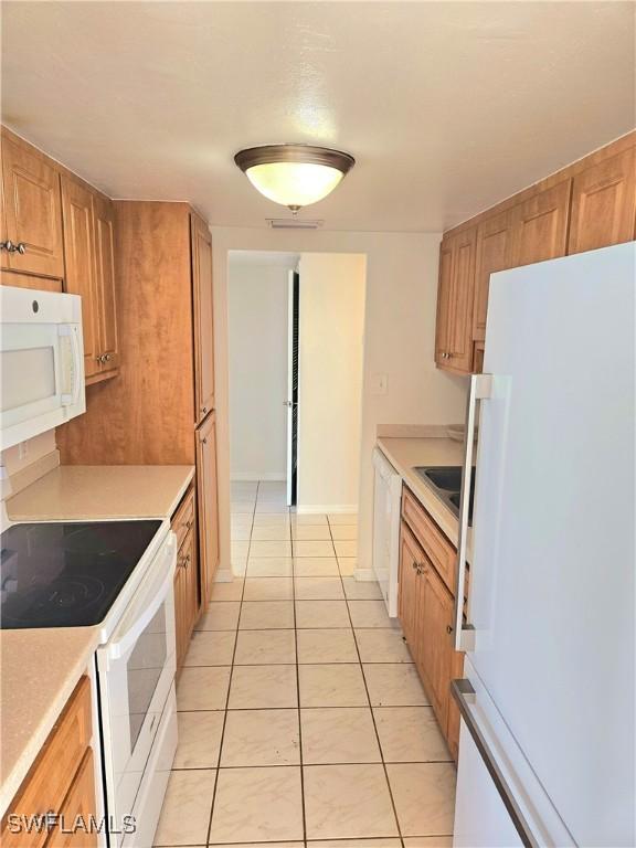 kitchen featuring white appliances and light tile patterned floors