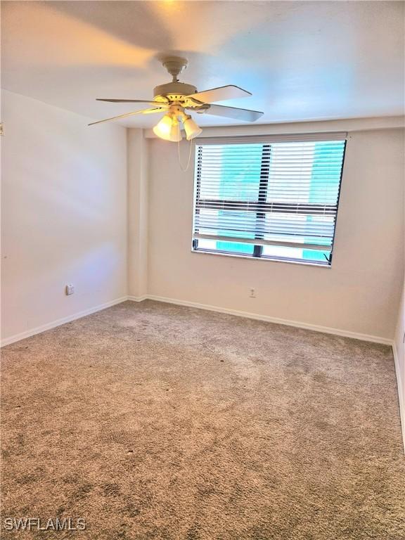 carpeted empty room featuring ceiling fan