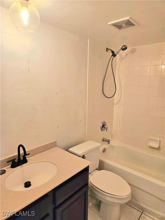 full bathroom featuring vanity, tile patterned floors, tiled shower / bath combo, and toilet