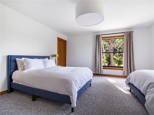 carpeted bedroom featuring baseboards