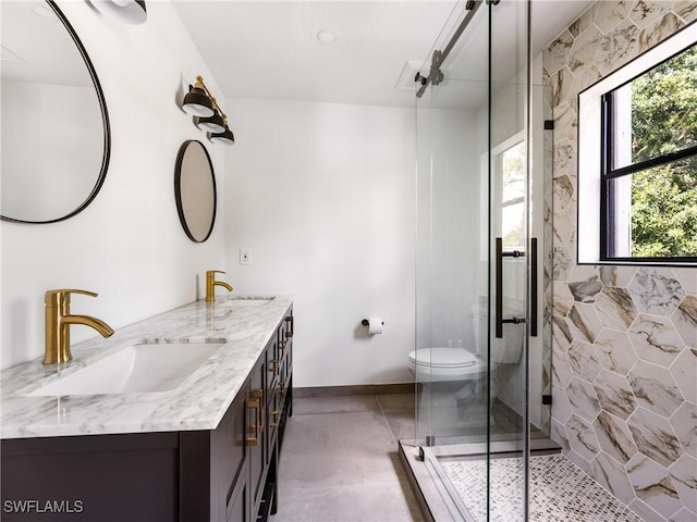 full bath with a sink, a shower stall, toilet, and double vanity