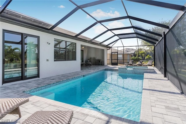 view of pool featuring glass enclosure, an in ground hot tub, and a patio area