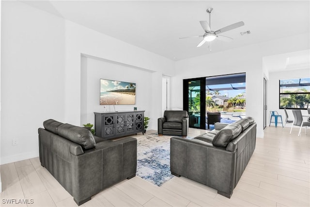 living room with ceiling fan and light wood-type flooring