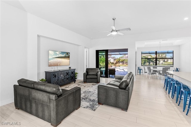 living room with light hardwood / wood-style flooring and ceiling fan