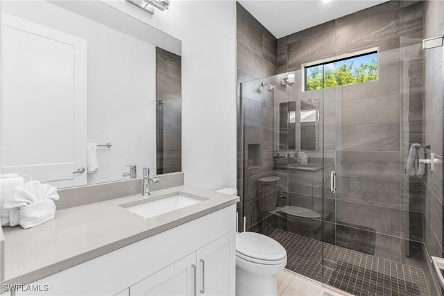 bathroom featuring tile patterned floors, a shower with door, vanity, and toilet