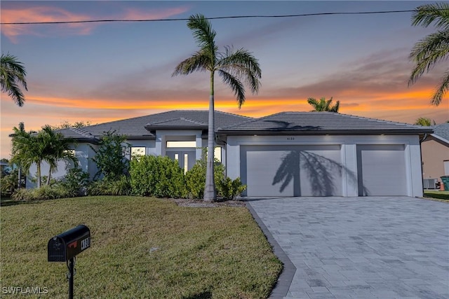 view of front of house with a garage and a lawn