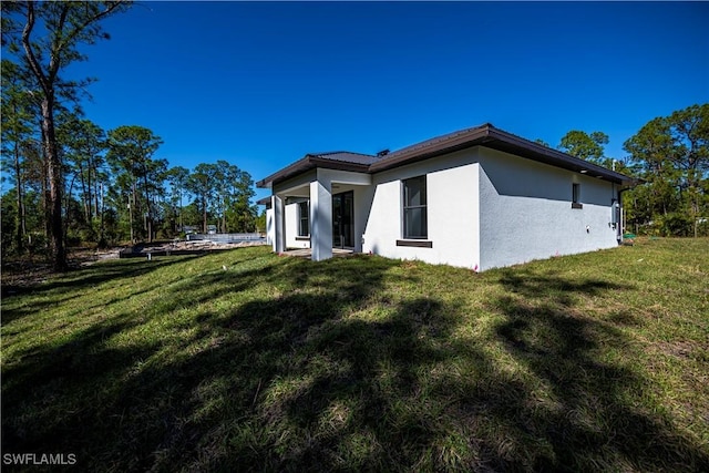 view of side of home with a yard