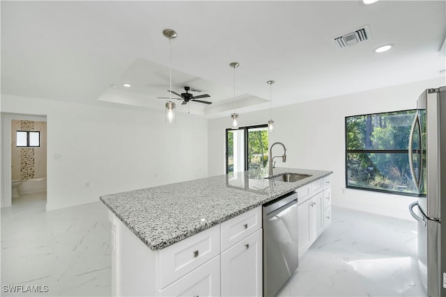 kitchen featuring ceiling fan, sink, stainless steel appliances, a center island with sink, and white cabinets