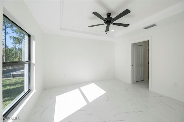 unfurnished room featuring a raised ceiling and ceiling fan