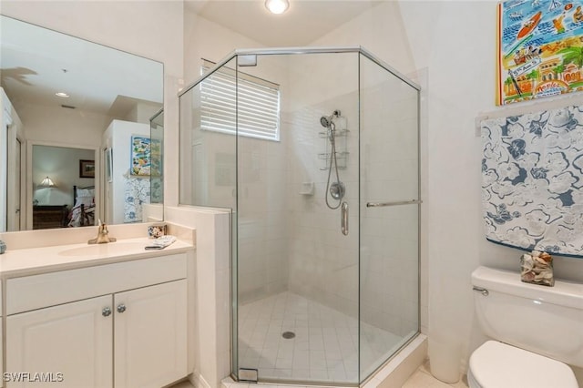 bathroom featuring vanity, toilet, and a shower with shower door