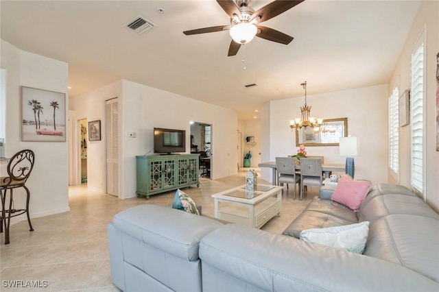 living room with ceiling fan with notable chandelier and light tile patterned floors