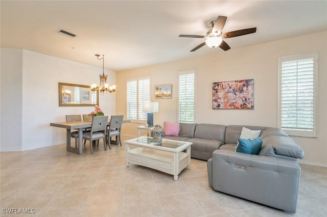 tiled living room featuring ceiling fan with notable chandelier