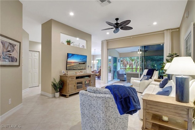 tiled living room with ceiling fan with notable chandelier