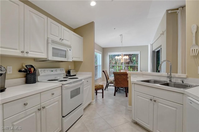 kitchen featuring white appliances, sink, decorative light fixtures, a notable chandelier, and white cabinets